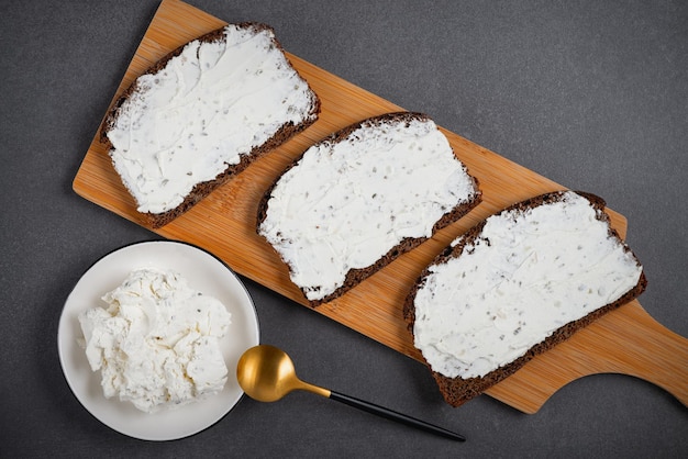 Pane di segale con crema di formaggio sul tavolo grigio