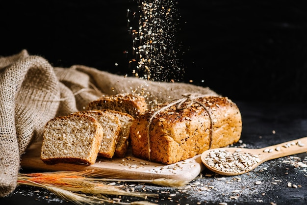 Pane di segale dolce con ingredienti diversi su fondo di legno nero