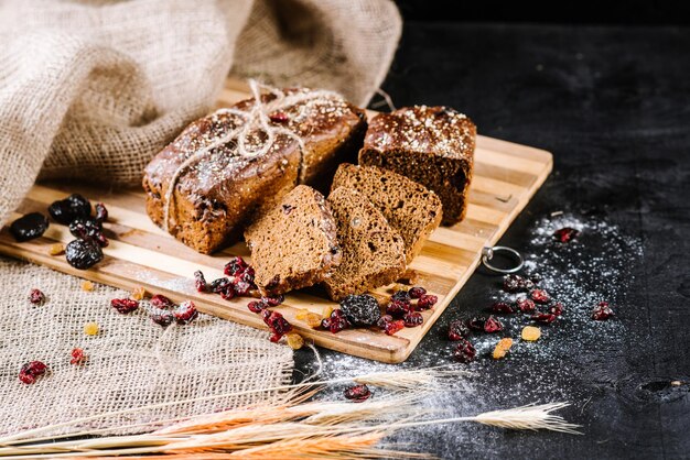 Pane di segale dolce e grano su fondo di legno nero