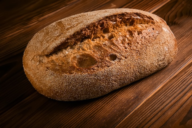 Pane di segale integrale su un tagliere su una superficie di legno marrone