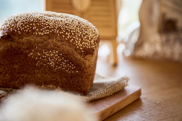 Pane di sesamo naturale a lievitazione naturale su tagliere di legno Pagnotta di pane Sfondo alimentare beige