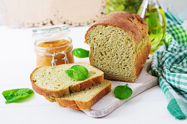 Pane di spinaci di recente al forno su una tavola di legno bianca. Stile rustico. Cibo da forno.