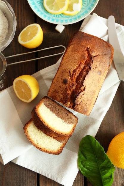 Pane dolce delizioso della torta con i limoni sulla vista superiore d'appoggio di legno