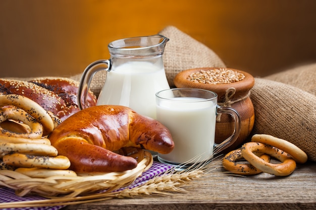 Pane e bagel con una brocca di latte