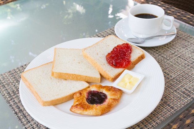 pane e burro marmellata nel piatto con caffè