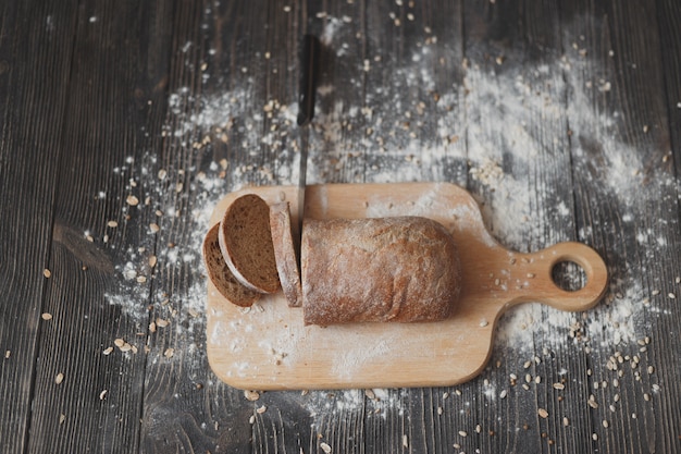 Pane e coltello affettati sul primo piano di legno del tagliere