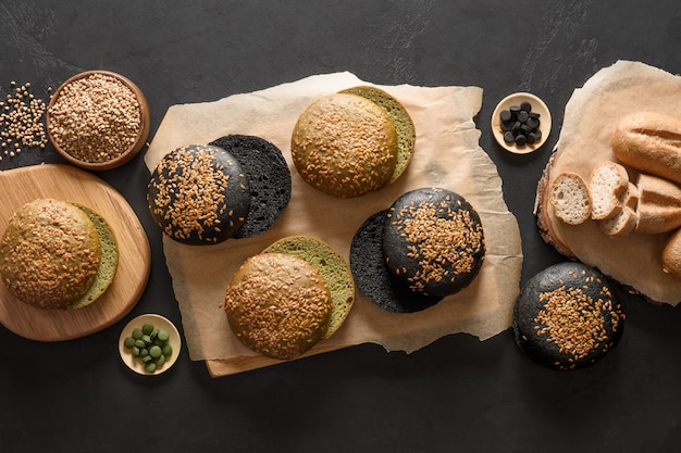 Pane e focacce vegane senza glutine di vari tipi con carbone di spirulina di grano saraceno su fondo nero