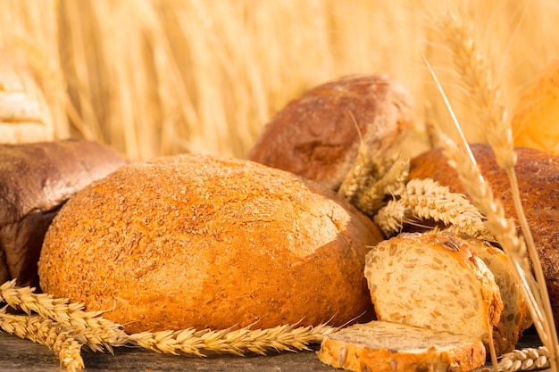 Pane e grano fatti in casa sul tavolo di legno nel campo autunnale