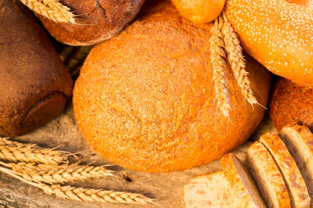 Pane e grano fatti in casa sul tavolo di legno nel campo autunnale