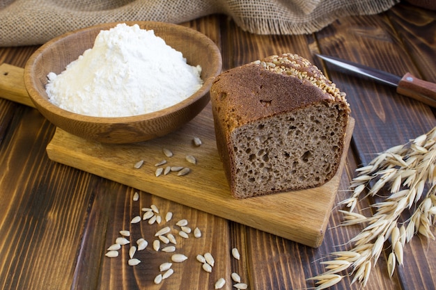 Pane fatto in casa a fette sul tagliere sullo sfondo di legno marrone