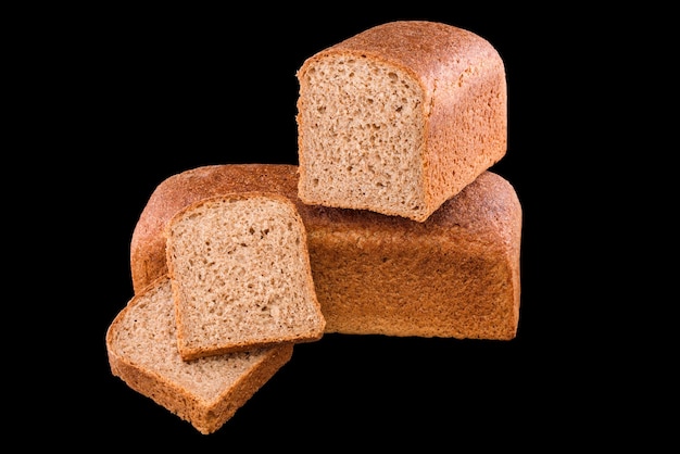 Pane fatto in casa appena sfornato isolato sul nero, tagliato a metà pane di segale con fette
