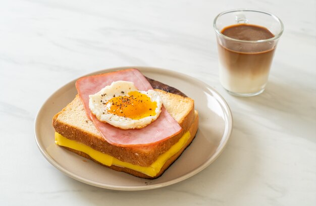 pane fatto in casa formaggio tostato condito con prosciutto e uovo fritto con salsiccia di maiale e caffè per colazione