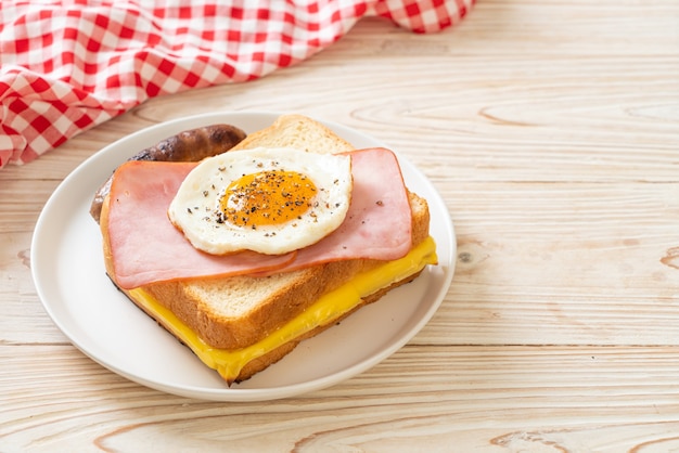 pane fatto in casa formaggio tostato condito con prosciutto e uovo fritto con salsiccia di maiale per colazione