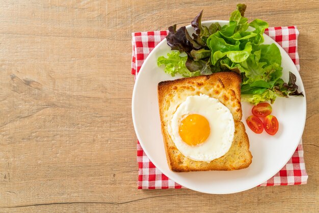 pane fatto in casa tostato con formaggio e uovo fritto in cima con insalata di verdure per colazione