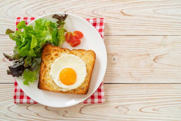 pane fatto in casa tostato con formaggio e uovo fritto sopra con insalata di verdure per colazione