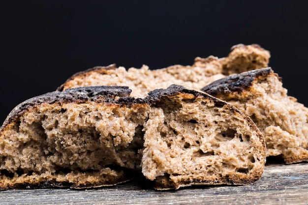 Pane fondente spezzettato con una crosta croccante su un tavolo di legno, una pagnotta di delizioso pane casereccio dalla polpa morbida e profumata