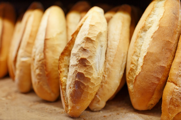 Foto pane fragrante e croccante appena sfornato dal forno si trova e viene conservato sul bancone per la vendita