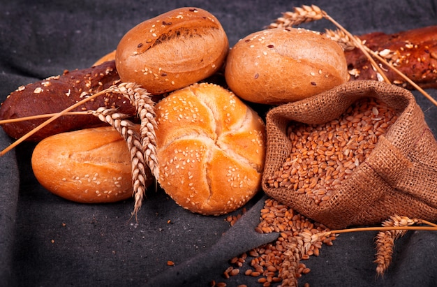 Pane fragrante fresco sul tavolo. Concetto di cibo. Panetteria, croccanti pagnotte di pane e focacce. Assortimento di pane cotto