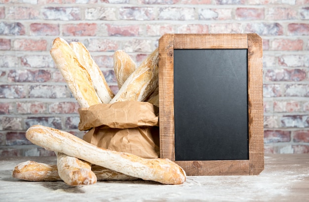 Pane francese con la lavagna su una tavola rustica