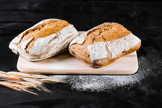 Pane francese fresco su fondo di legno nero