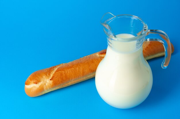 Pane fresco delle baguette e brocca con latte fresco isolato