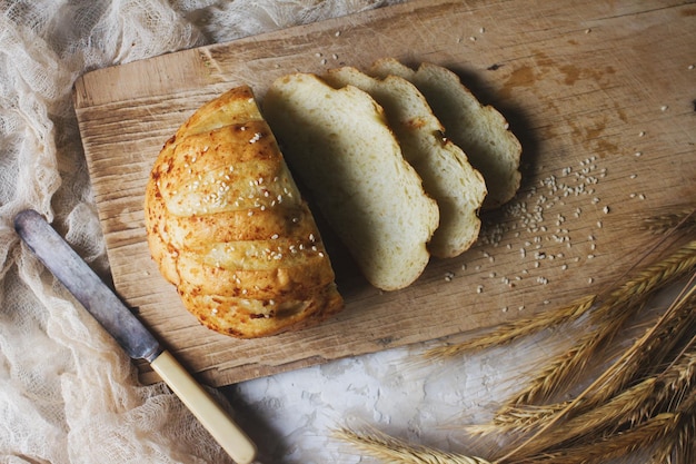 Pane fresco e spighe di grano su tavola di legno rustica vista dall'alto fuoco selettivo