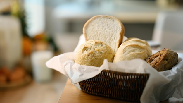 Pane fresco fatto in casa in cesto su tavolo di legno in cucina Mangiare sano e concetto di panetteria tradizionale