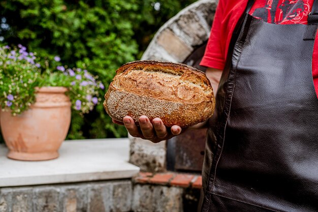 Pane fresco fatto in casa nella mano del fornaio