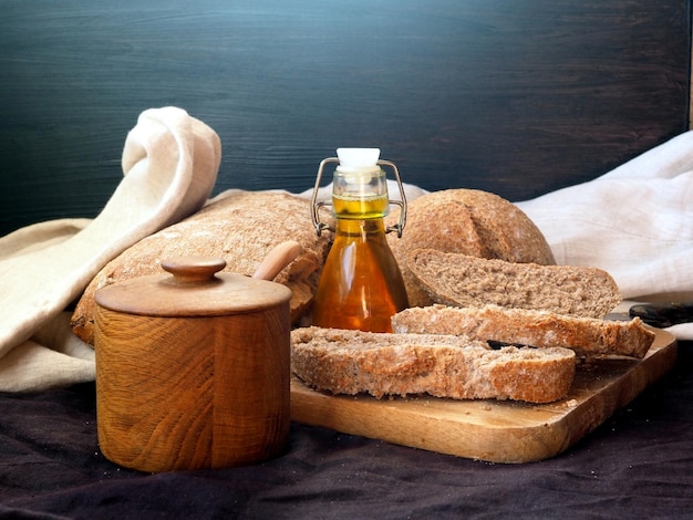 Pane fresco fatto in casa una bottiglia di olio d'oliva un tagliere di legno una saliera di legno