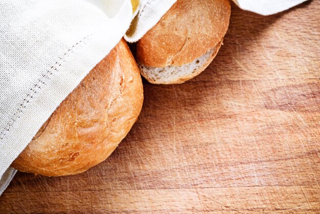 Pane fresco sotto un tovagliolo di lino su un legno