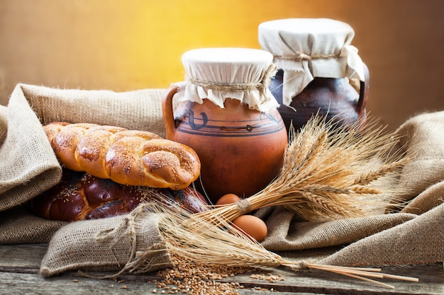 Pane fresco su uno sfondo vecchio con accessori da cucina sul tavolo.