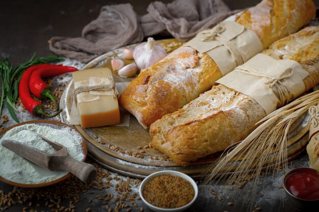 Pane fresco su uno sfondo vecchio con accessori da cucina sul tavolo.