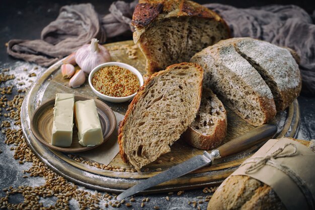 Pane fresco su uno sfondo vecchio con accessori da cucina sul tavolo.