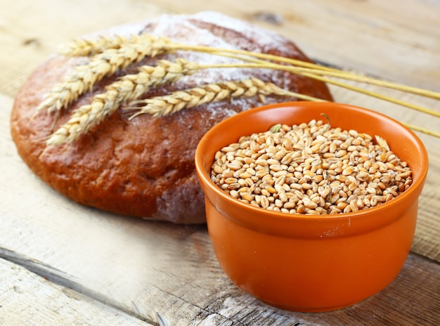 Pane fresco su uno sfondo vecchio con accessori da cucina sul tavolo