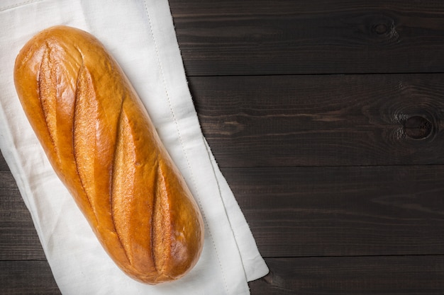 Pane fresco sul panno contro fondo di legno scuro