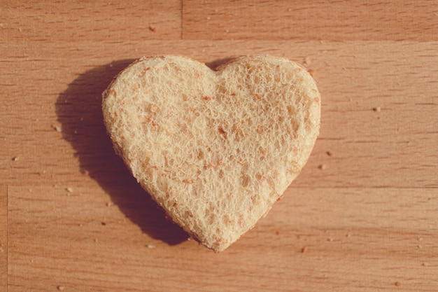 Pane granulato tagliato a forma di cuore. Concetto di amore e cura nel giorno di San Valentino.