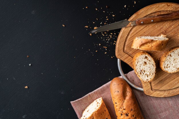 Pane gustoso fresco o baguette sulla superficie del nero in cucina