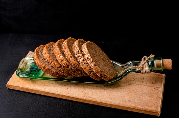 Pane integrale a fette con semi di lino, semi di girasole e sesamo su un piatto di vetro