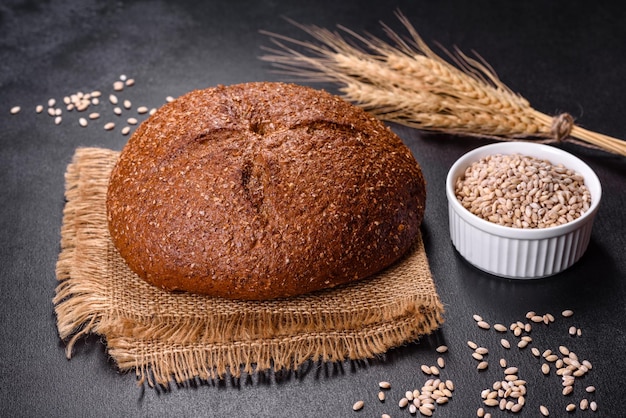 Pane integrale appena sfornato con spighe e chicchi di grano