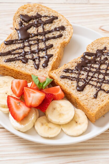 pane integrale con banana fresca, fragole e cioccolato