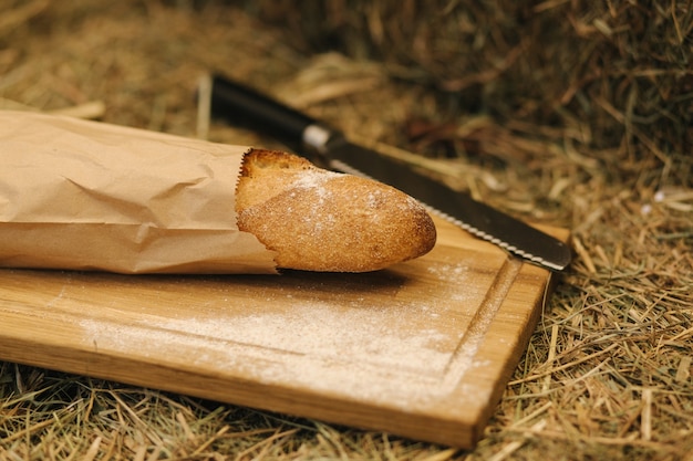 Pane integrale cotto a casa tavola di legno su ingredienti bio di fieno