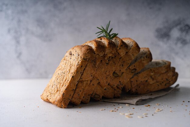 Pane integrale fatto in casa a fette fresche su sfondo rustico bianco Pasta madre artigianale