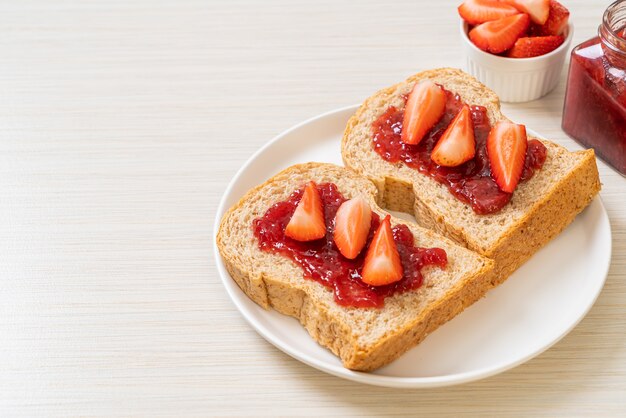 pane integrale fatto in casa con marmellata di fragole e fragole fresche