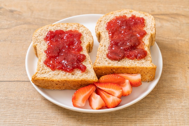 pane integrale fatto in casa con marmellata di fragole e fragole fresche