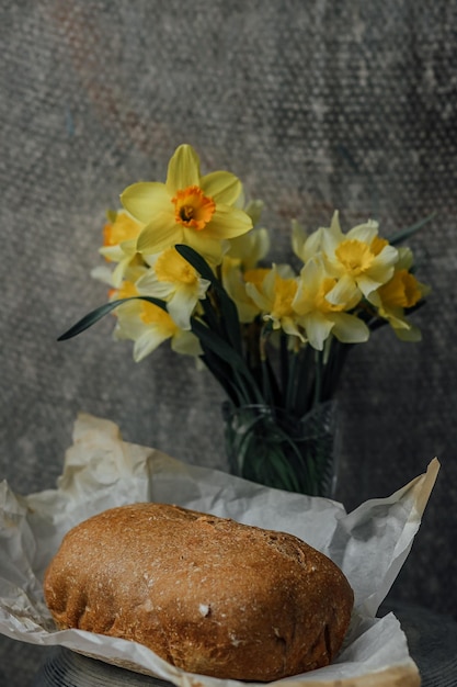 Pane integrale fatto in casa delizioso e sano con miele posto per fiori gialli di testo
