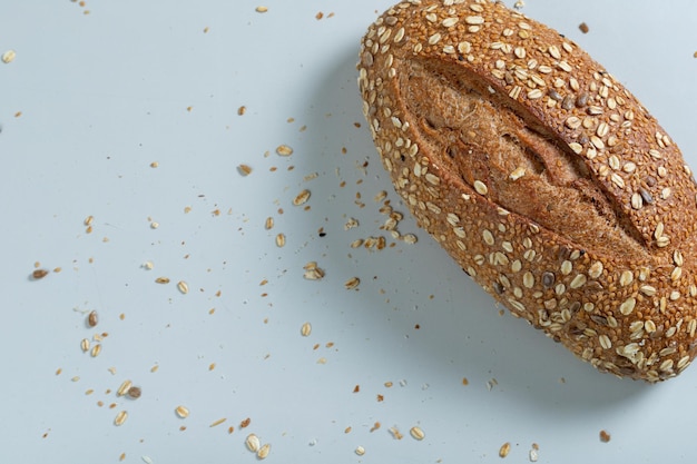 Pane integrale sano della pagnotta artigianale su una tavola bianca