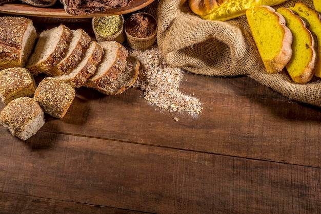 Pane integrale su tavola di legno rustica con ingredienti in background vista dall'alto spazio copia