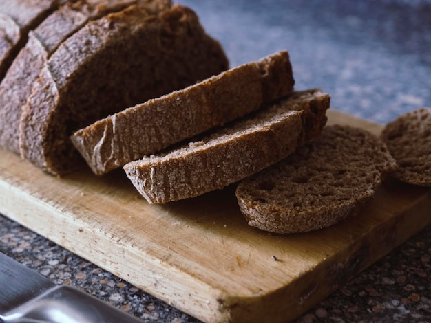 Pane integrale tagliato a fette su un tagliere di legno