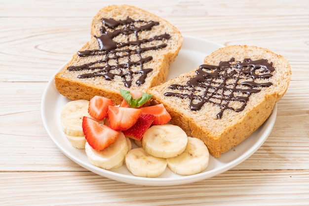 pane integrale tostato con banana fresca, fragola e cioccolato per colazione