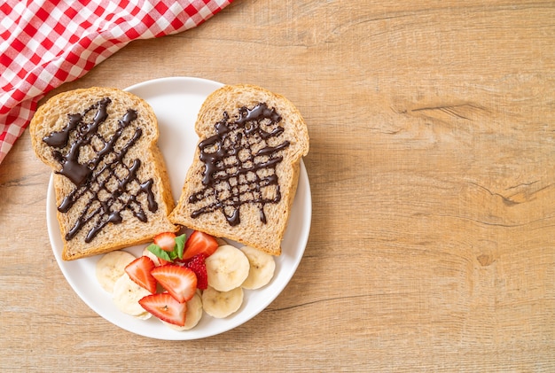 pane integrale tostato con banana fresca, fragola e cioccolato per colazione